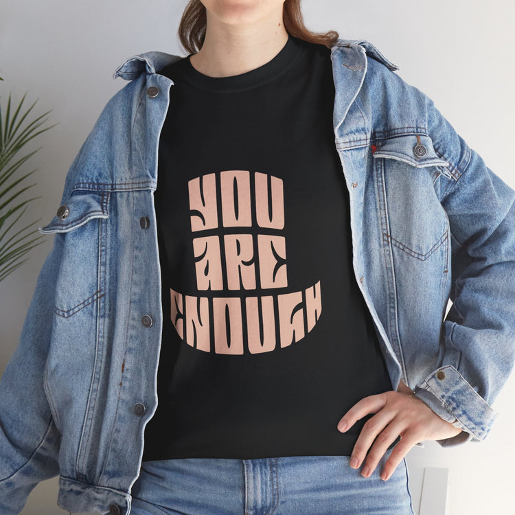 Empowerment Wear and Merchandise, a person wearing a black shirt that says You Are Enough, with a denim jacket and jeans