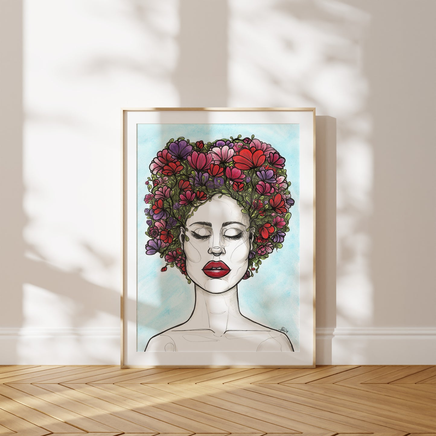Framed artwork of a woman's face with a floral crown on a light background. A piece on battling breast cancer and going through chemotherapy.