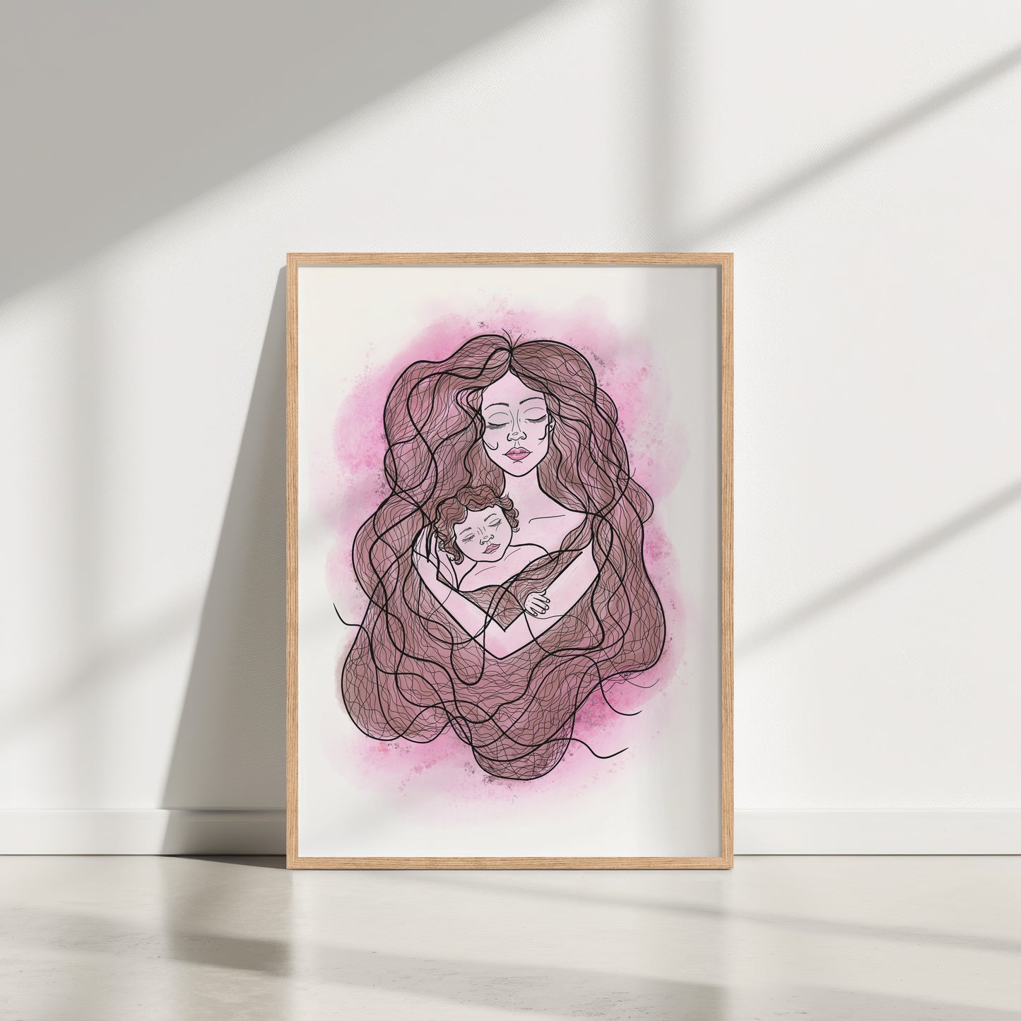 Framed artwork of a woman holding a child with a pink watercolor background on a white wall.