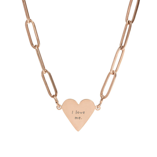 Rose gold necklace with a heart-shaped pendant  with the text "I love me." on a white background